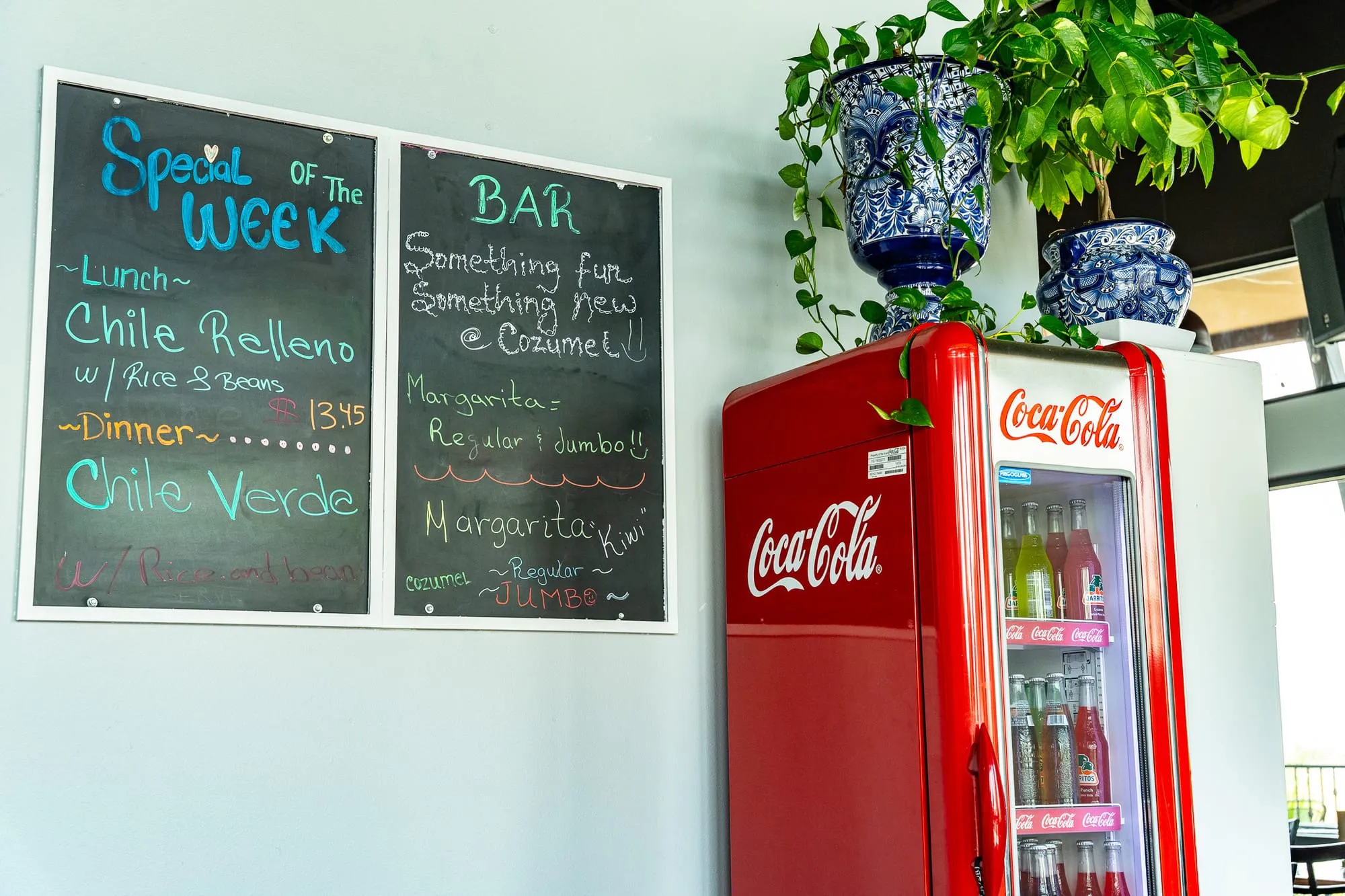 The Cozumel bar lined with tequilas and spirits, a handwritten chalkboard, and a vintage red cooler