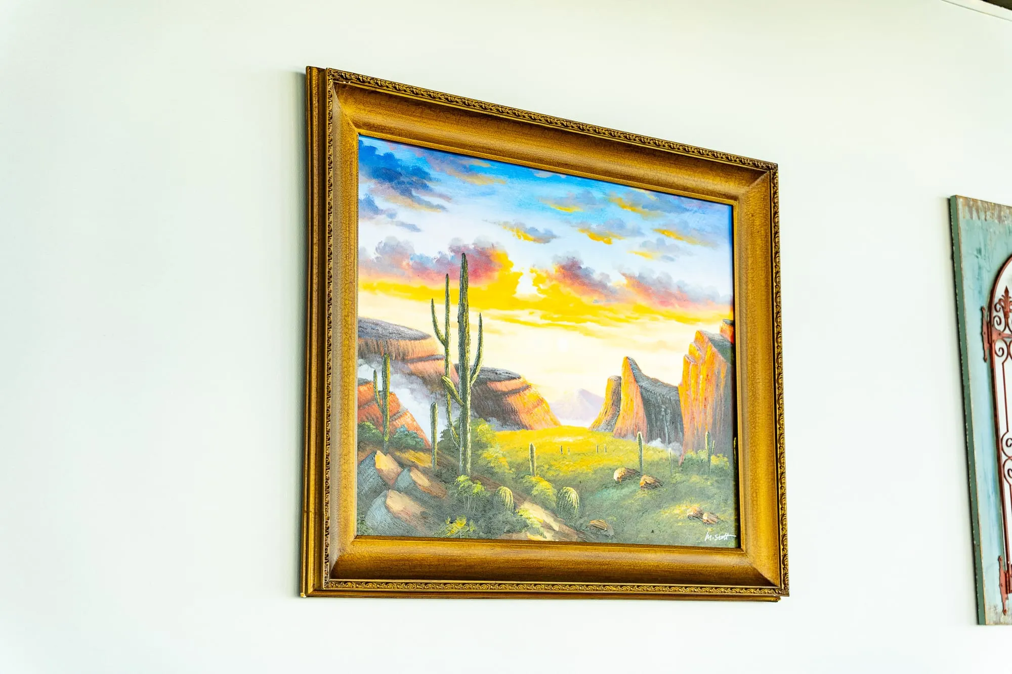 A framed painting of a sunlit coastal landscape on the wall at Cozumel Mexican Cuisine
