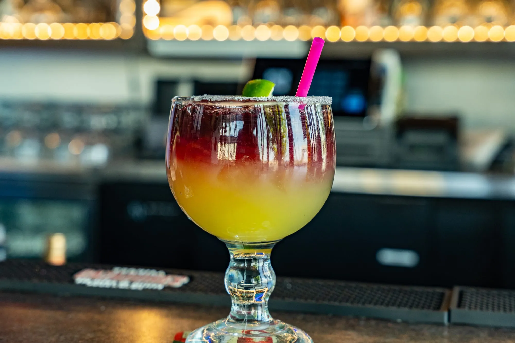 A layered red-and-gold sunrise margarita served at the Cozumel bar